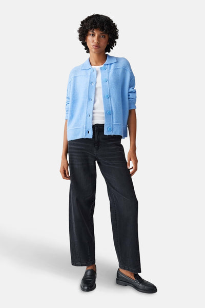 Pull bleu d'OPUS, porté avec un t-shirt blanc et un jean noir délavé avec des mocassins noirs.