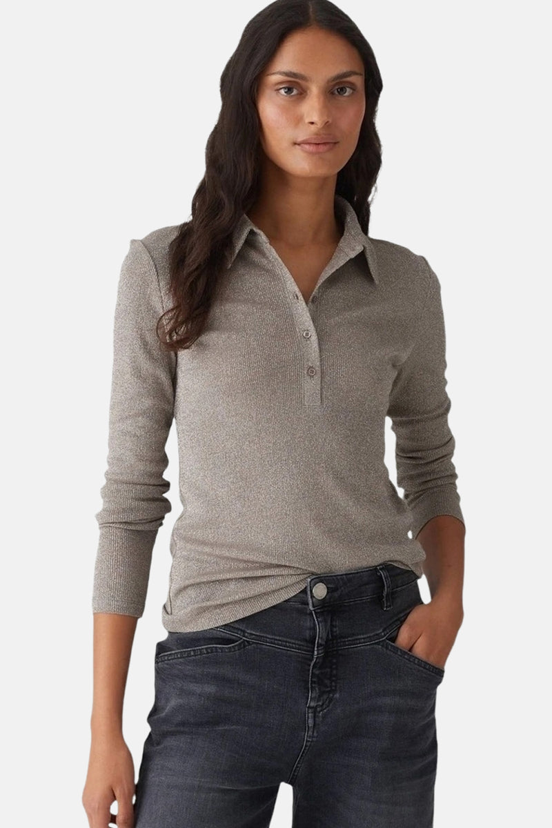 Polo à manches longues beige d'OPUS, en maille côtelée avec un col classique et patte de boutonnage, porté avec un jean noir.