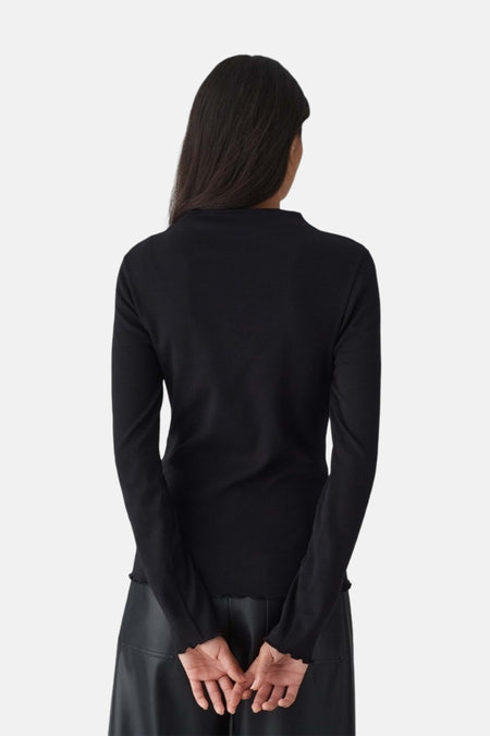Vue de dos d’un pull noir OPUS à manches longues porté avec un pantalon noir.