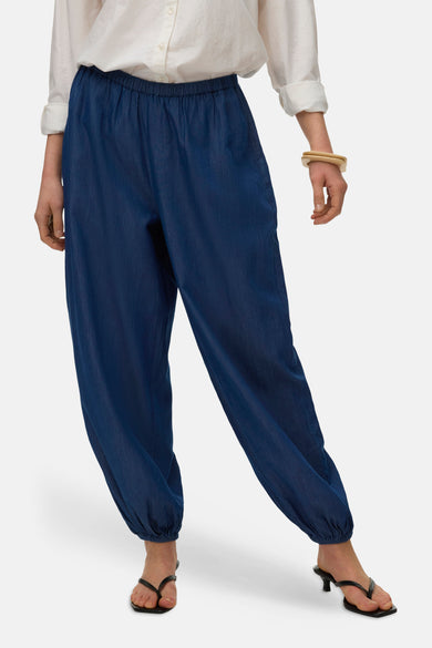 Pantalon bleu en denim par VERO MODA, style décontracté avec taille élastique et chaussures à talons noires.