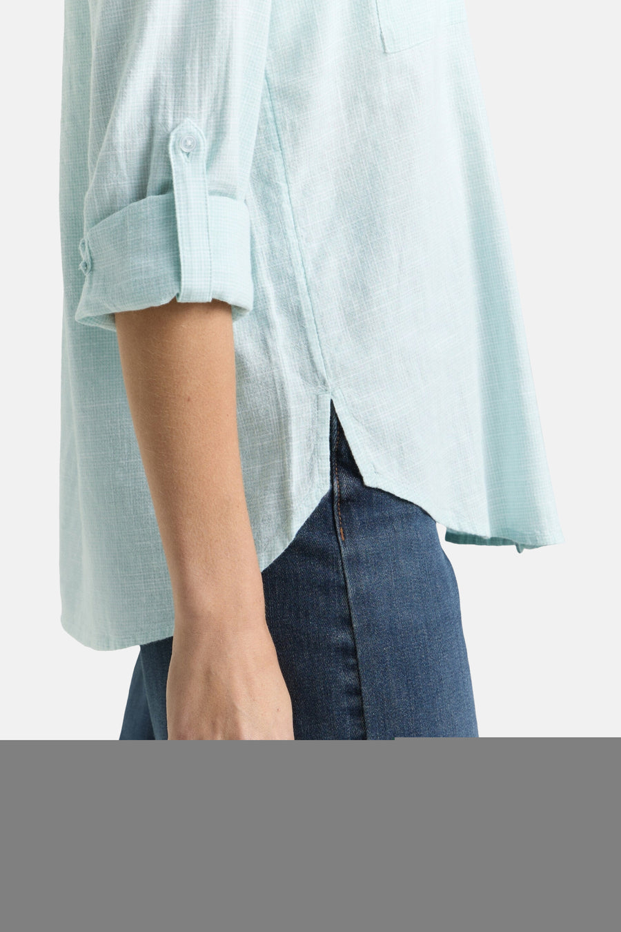 Chemisier à manches longues vert de Tom Tailor, avec manches retroussées et ourlet fendu, porté avec un jean.