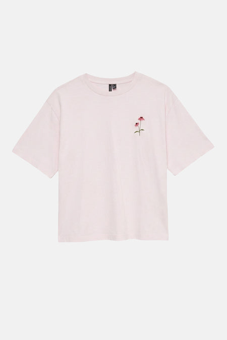 T-shirt rose pâle de VERO MODA avec broderie de deux fleurs roses sur la poitrine gauche.