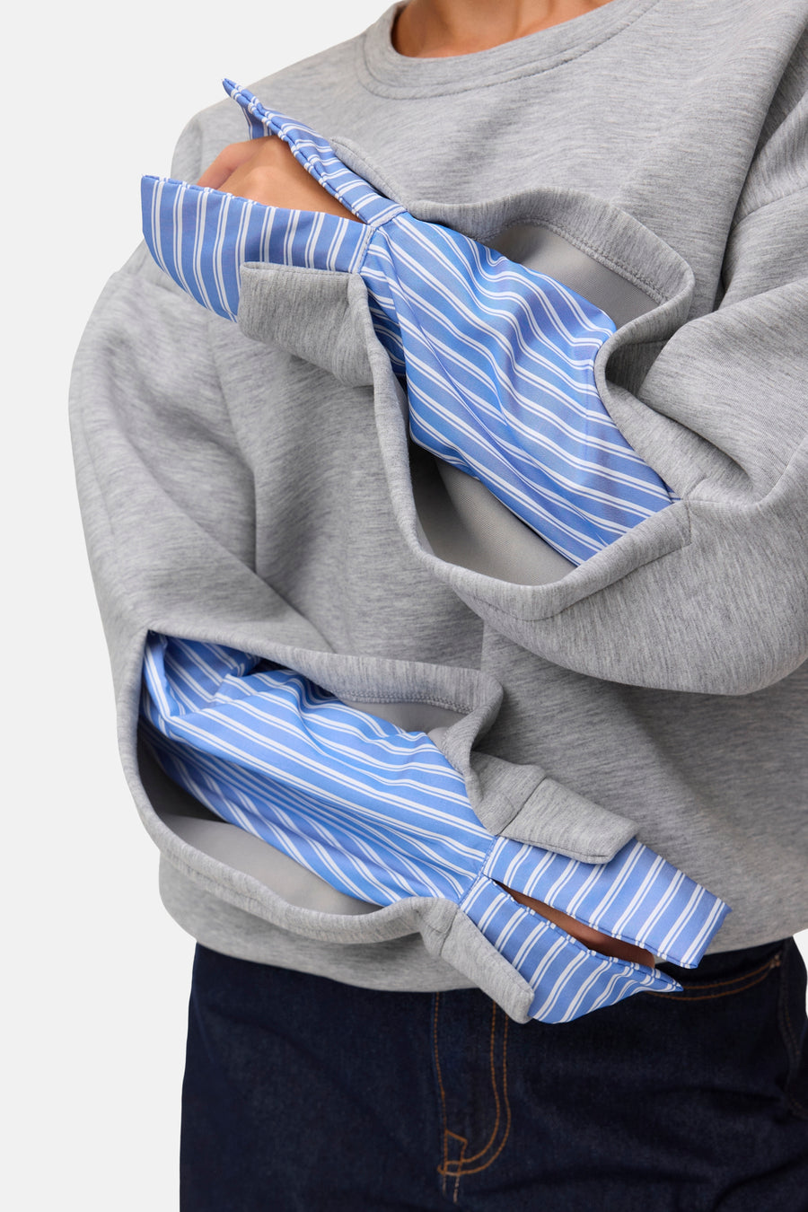 Light grey melange sweatshirt with blue and white striped lining, side view, worn over dark jeans