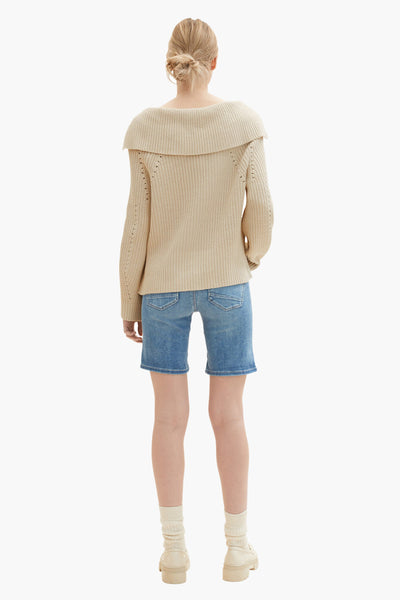 Blauwe bermuda van Tom Tailor, gedragen met een beige trui en crèmekleurige sokken.