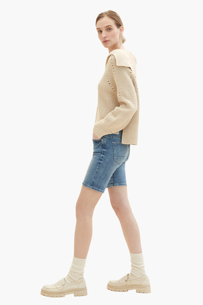 Blauwe Bermuda van Tom Tailor, gedragen met een beige geribbelde gebreide trui, bijpassende sokken en loafers.