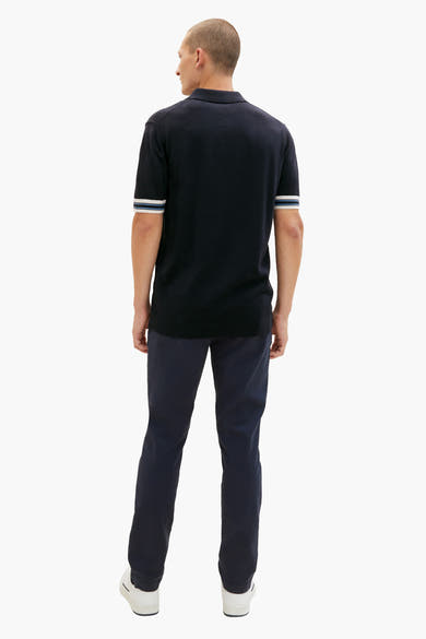 Chino bleu marine par Tom Tailor, porté avec un polo marine à rayures, et des baskets blanches.