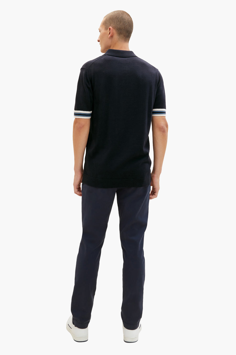 Chino bleu marine par Tom Tailor, porté avec un polo marine à rayures, et des baskets blanches.