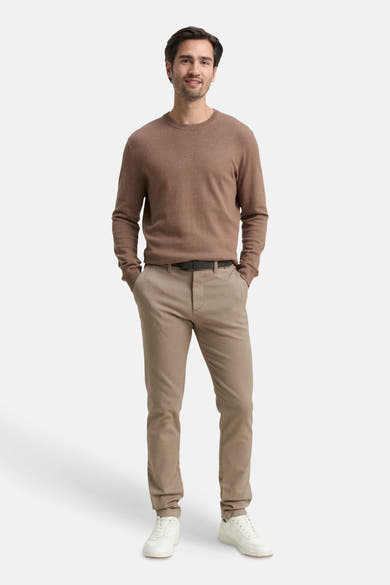 Bruine chino van Tom Tailor, gedragen met een bruine trui, zwarte riem en witte sneakers.