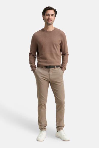 Brown chino pants with slim fit, worn by model in full-length front view, paired with brown sweater and white sneakers.