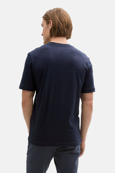 T-shirt bleu de Tom Tailor, modèle uni vu de dos porté avec un pantalon assorti.