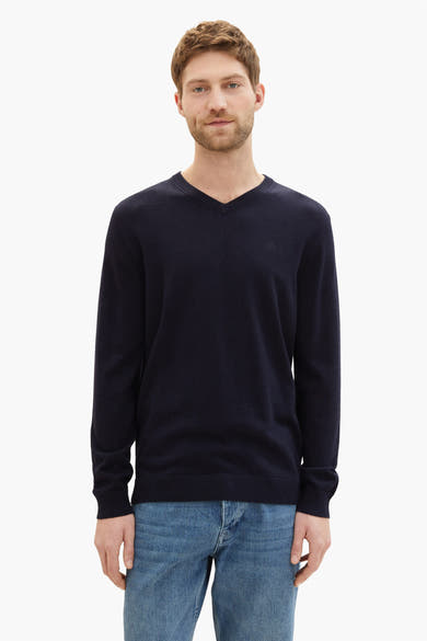 Marineblauwe V-hals trui van Tom Tailor, gedragen met een spijkerbroek.