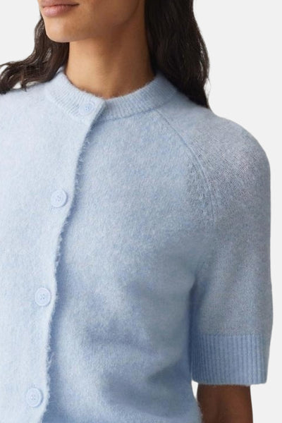 Cardigan bleu clair par OPUS, en maille duveteuse à manches courtes et fermeture boutonnée ton sur ton.

