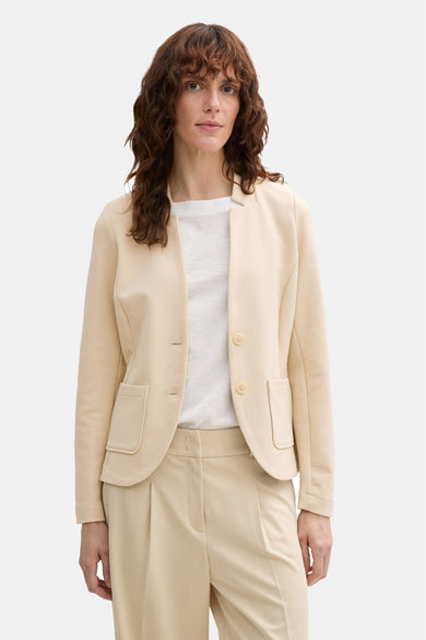 Tom Tailor beige blazer, met gestikte en en fineine texture texture, gedragen over een eenvoudig wit t-shirt en een passende broek.