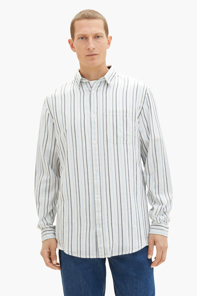 Chemise à manches longues rayée blanche par Tom Tailor, avec poche poitrine et coupe classique, portée avec un jean.