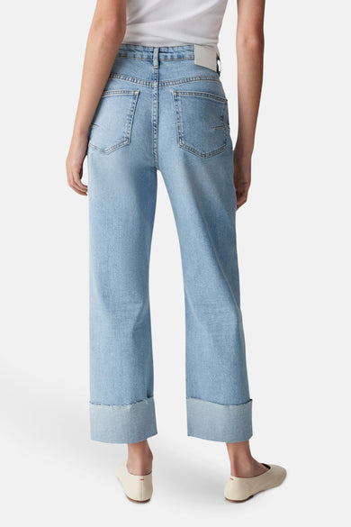 Jean droit en denim bleu clair d'OPUS, avec ourlets retroussés et poches arrière, porté avec des ballerines crème.