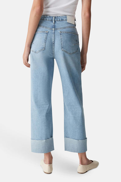 Jean droit en denim bleu clair d'OPUS, avec ourlets retroussés et poches arrière, porté avec des ballerines crème.