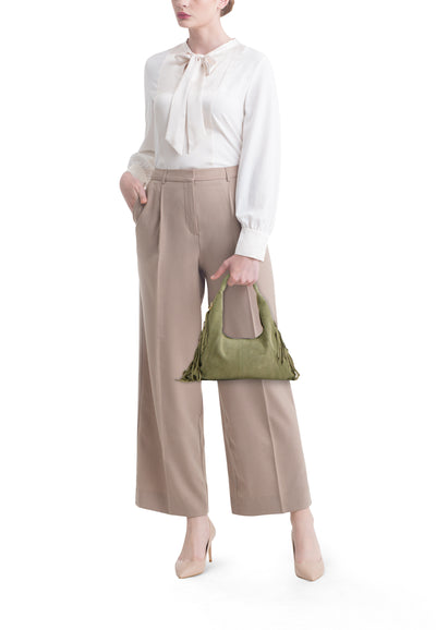 Sac à bandoulière vert de Access®, porté avec un chemisier ivoire et un pantalon beige.