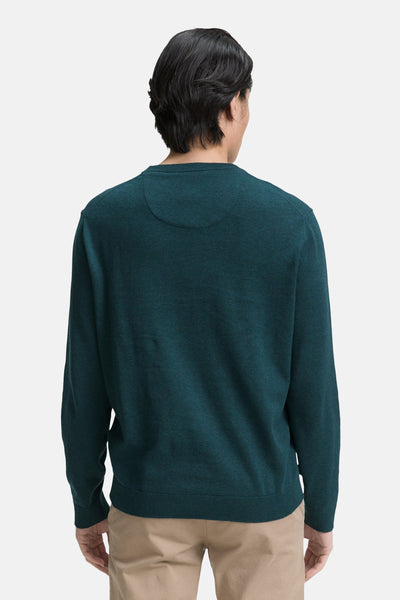 Pull à col rond vert par Tom Tailor, avec détails texturés discrets, porté avec un pantalon beige.
