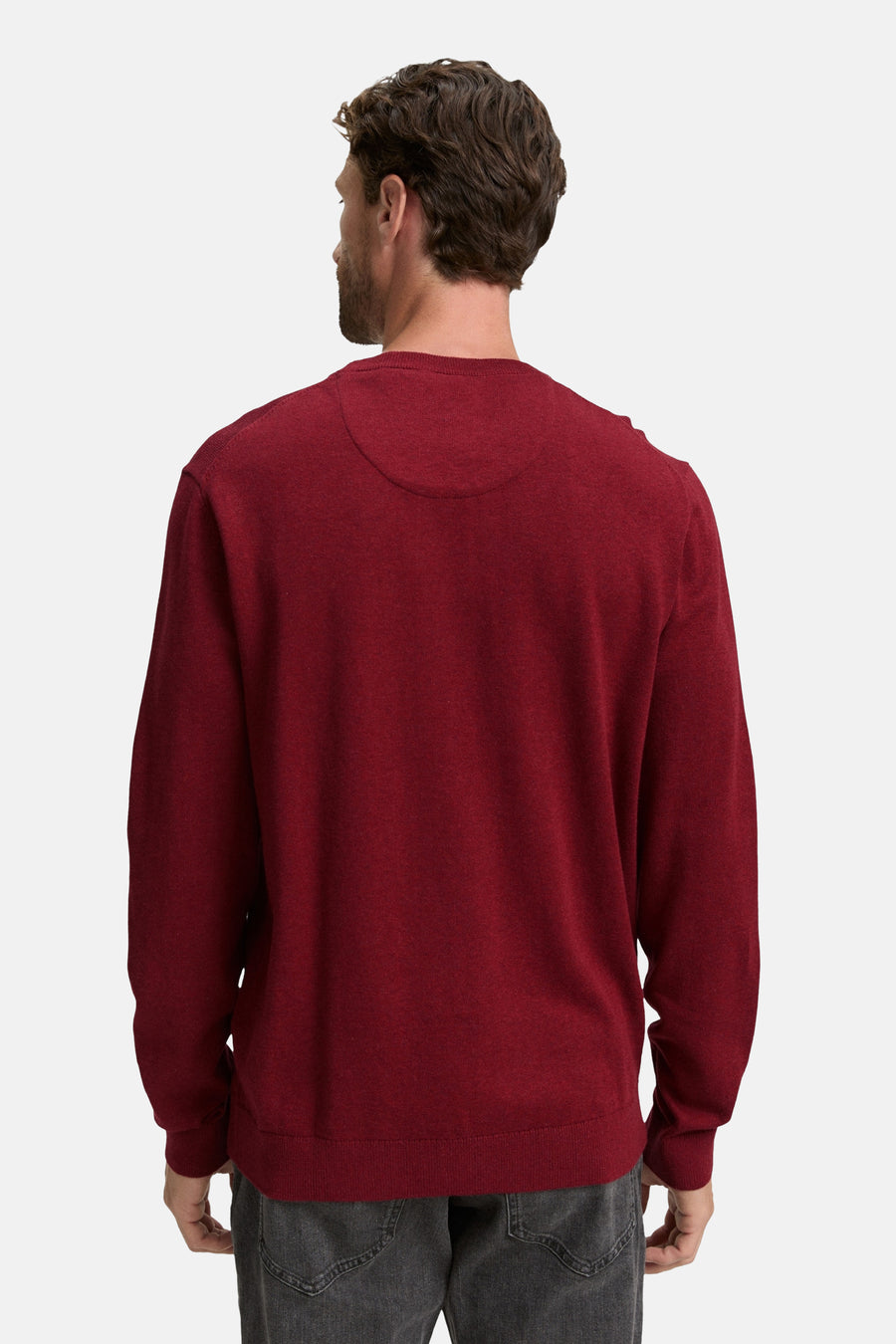 Rode rondehals trui van Tom Tailor, achterkant, gedragen met een lichtgrijze broek.