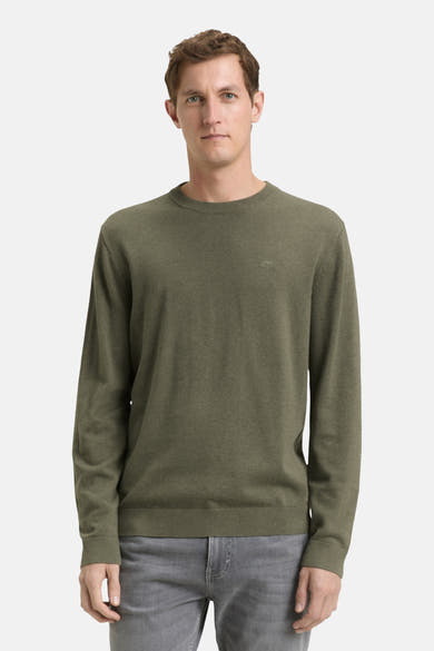 Pull à col rond vert de Tom Tailor, porté avec un pantalon gris, devant un fond blanc.
