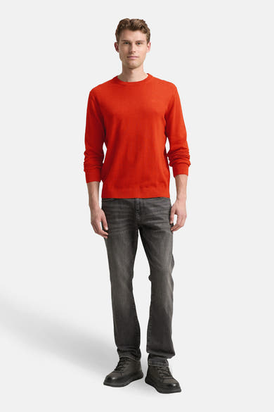 Pull à col rond orange de Tom Tailor, porté avec un jean gris et des chaussures noires.