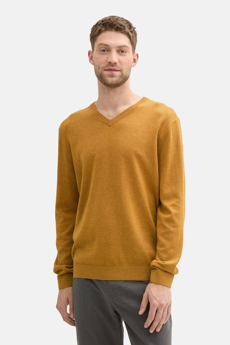 Okergele rondehals trui van Tom Tailor, van achteren gezien, gedragen met een grijze broek.