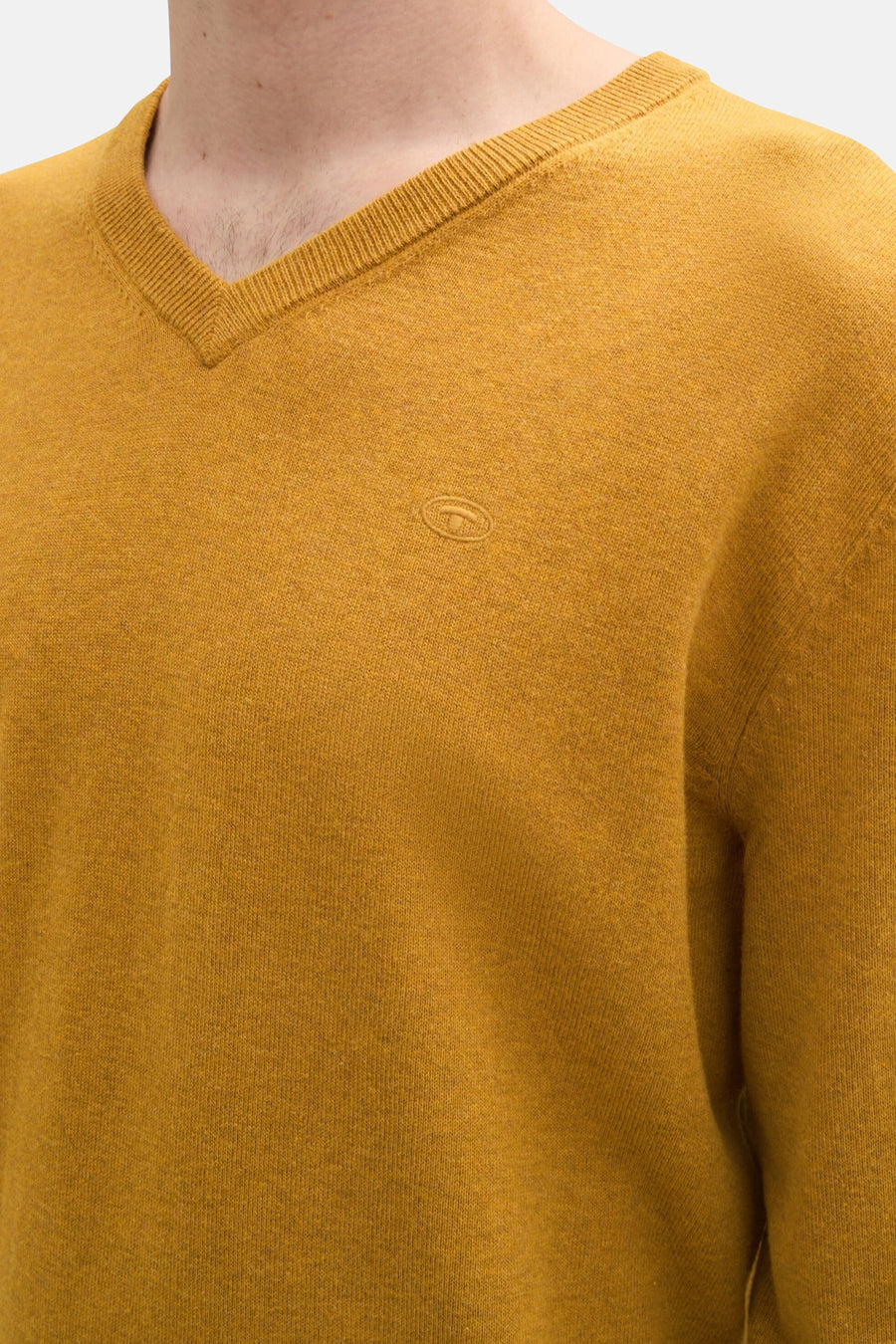Pull col V ocre de Tom Tailor, en maille fine avec un petit logo sur la poitrine.