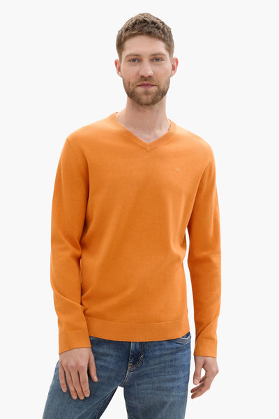 Pull à col rond orange de Tom Tailor, porté avec un jean bleu.