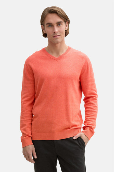 Oranje trui met een V-kraag van Tom Tailor, gedragen met een donkere broek.