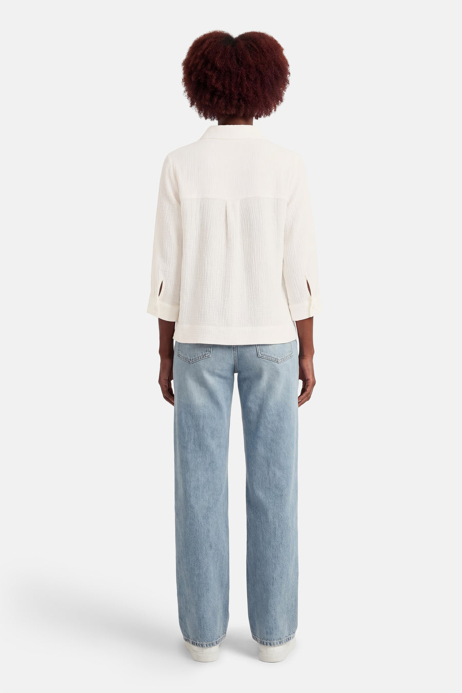 Chemise blanche à manches longues de OPUS, texture gaufrée, coupe ample et décontractée, portée avec un jean bleu clair.