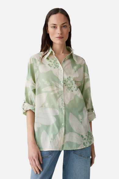 Groen overhemd met lange mouwen van OPUS, met wit bloemenpatroon en opgerolde mouwen, gedragen met een blauwe jeans.