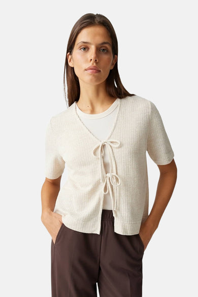 Blouse beige à manches courtes d'OPUS, nouée sur le devant, portée sur un débardeur blanc avec un pantalon marron.