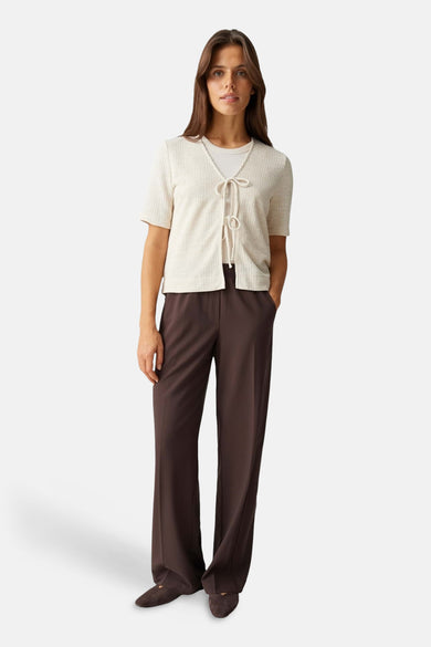Blouse beige d'OPUS, manches courtes, texture côtelée, portée sur un t-shirt blanc et un pantalon marron.