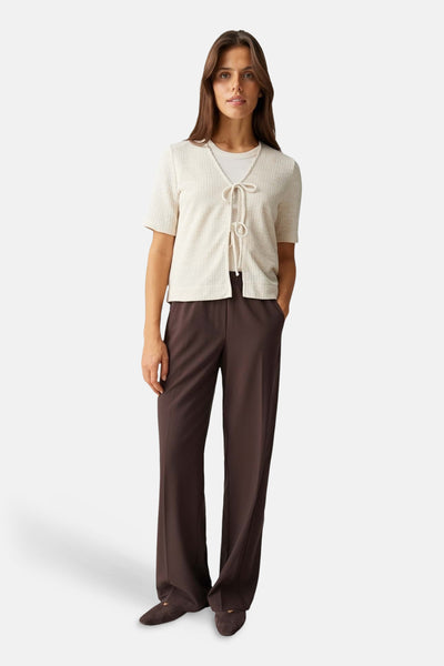 Blouse beige d'OPUS, manches courtes, texture côtelée, portée sur un t-shirt blanc et un pantalon marron.