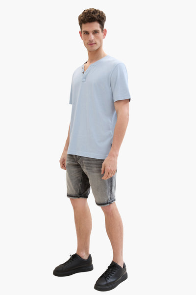 Short en denim gris clair de Tom Tailor, porté avec un t-shirt bleu clair et des baskets noires.
