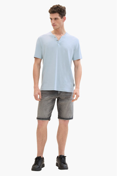 Korte spijkerbroek in lichtgrijs van Tom Tailor, gedragen met een lichtblauw T-shirt en zwarte schoenen.