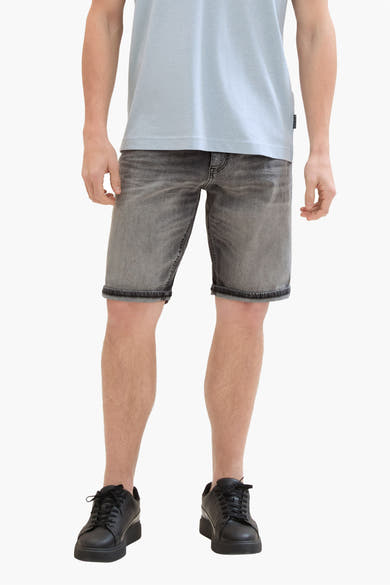 Korte spijkerbroek in lichtgrijs van Tom Tailor, met opgerolde zomen en gedragen met een lichtblauw T-shirt en zwarte sneakers.