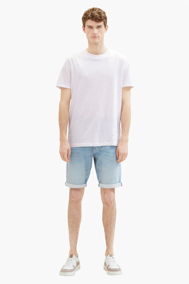 Korte spijkerbroek in lichtblauw van Tom Tailor, gedragen met een wit T-shirt en witte sneakers.