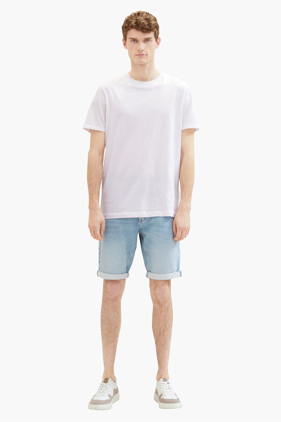 Korte spijkerbroek in lichtblauw van Tom Tailor, gedragen met een wit T-shirt en witte sneakers.