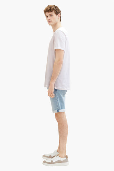 Korte spijkerbroek in lichtblauw van Tom Tailor, gedragen met een wit T-shirt en sneakers.