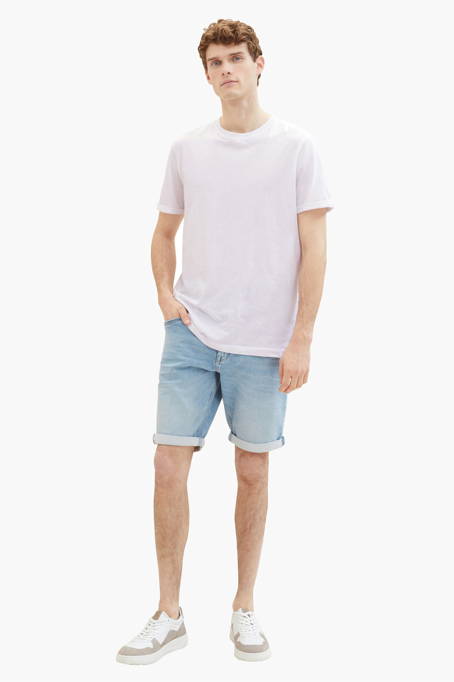 Korte spijkerbroek in lichtblauw van Tom Tailor, gedragen met een wit T-shirt en leren sneakers.