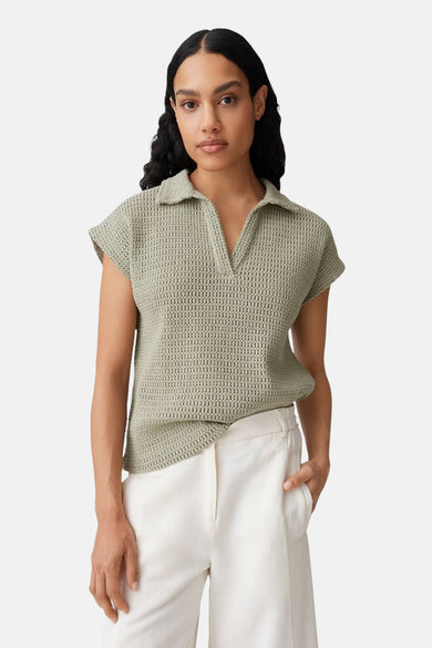 Groen OPUS poloshirt met korte mouwen en ajourbreisel, achterzijde, gedragen met een witte broek.