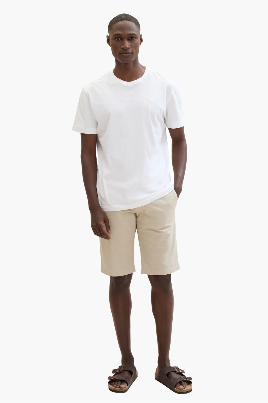 Korte beige short van Tom Tailor, gedragen met een wit T-shirt en bruine leren sandalen.