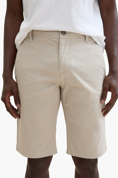 Korte beige short van Tom Tailor, met ritssluiting en knoop, gedragen met een wit T-shirt.