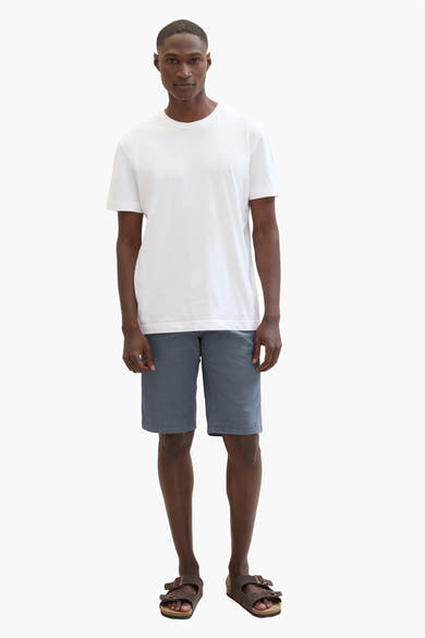 Short bleu de Tom Tailor, porté avec un t-shirt blanc et des sandales marron.