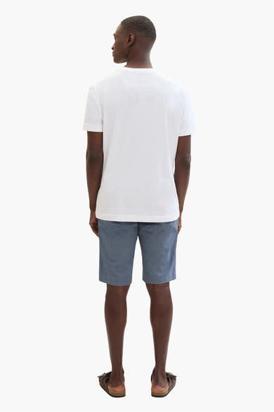 Korte blauwe jeans van Tom Tailor, gedragen met een effen wit T-shirt en bruine sandalen.