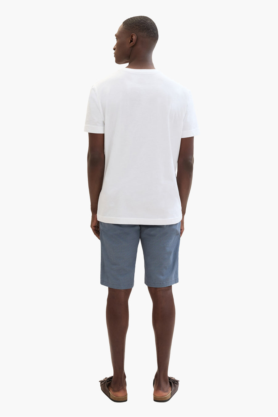 Korte blauwe jeans van Tom Tailor, gedragen met een effen wit T-shirt en bruine sandalen.