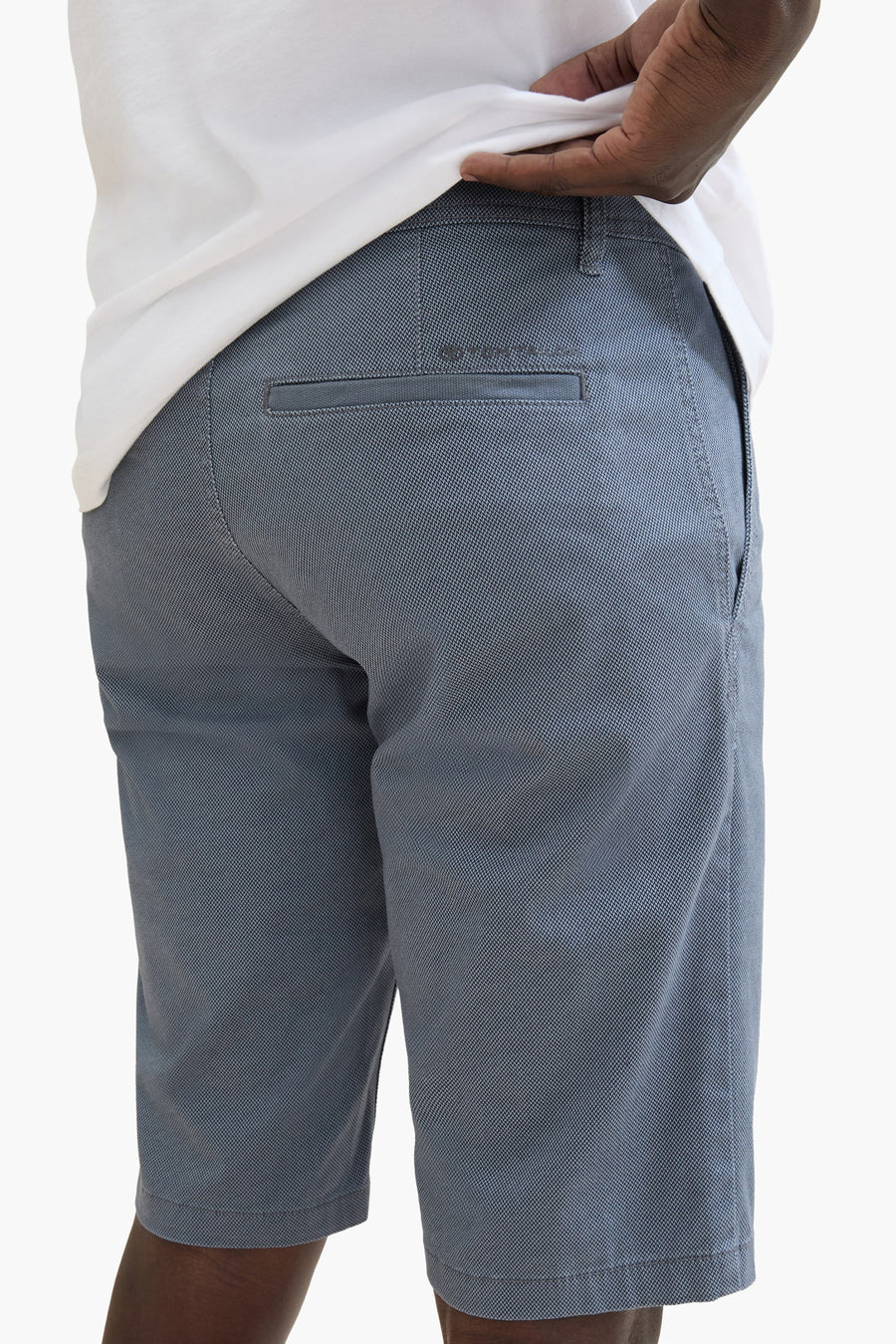 Korte blauwe van Tom Tailor, met een discreet patroon, paspelzak achter, gedragen met een wit T-shirt.