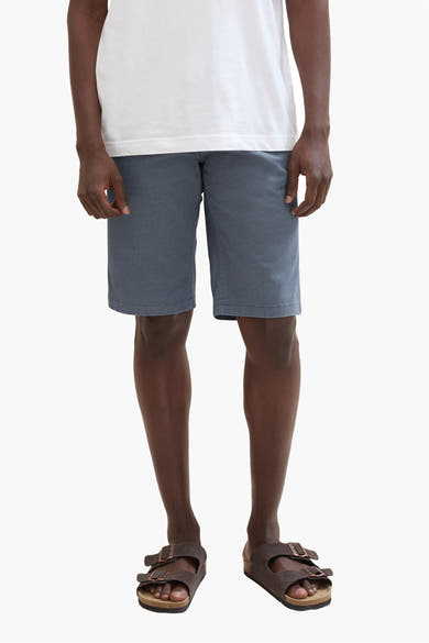 Korte blauwe van Tom Tailor, gedragen met een wit T-shirt en bruine sandalen.
