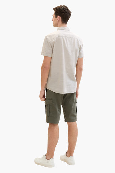 Tom Tailor bermudashort met cargozakken, gedragen met een beige overhemd en witte sneakers.